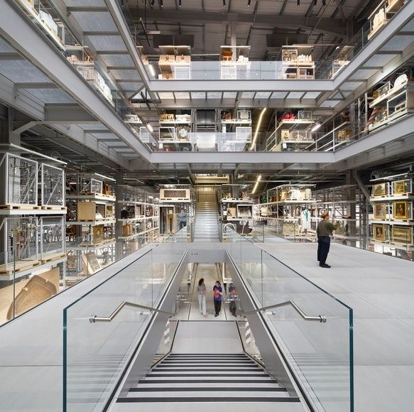 Flerplansmagasin med museiföremål, glasräcken och trappor